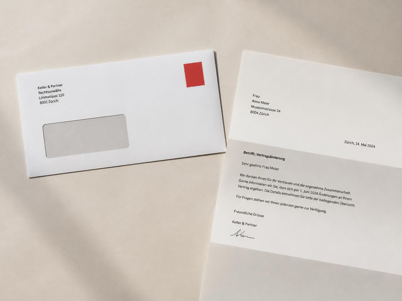Gedruckter Brief neben einem frankierten Umschlag auf hellem Papieruntergrund